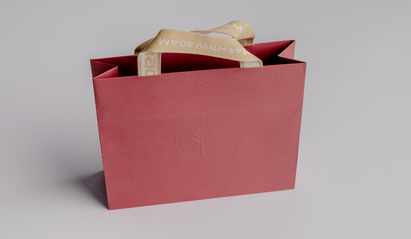 Earth in Mind red gift bag with a woven paper handle