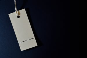White cardboard fashion label on a blue background