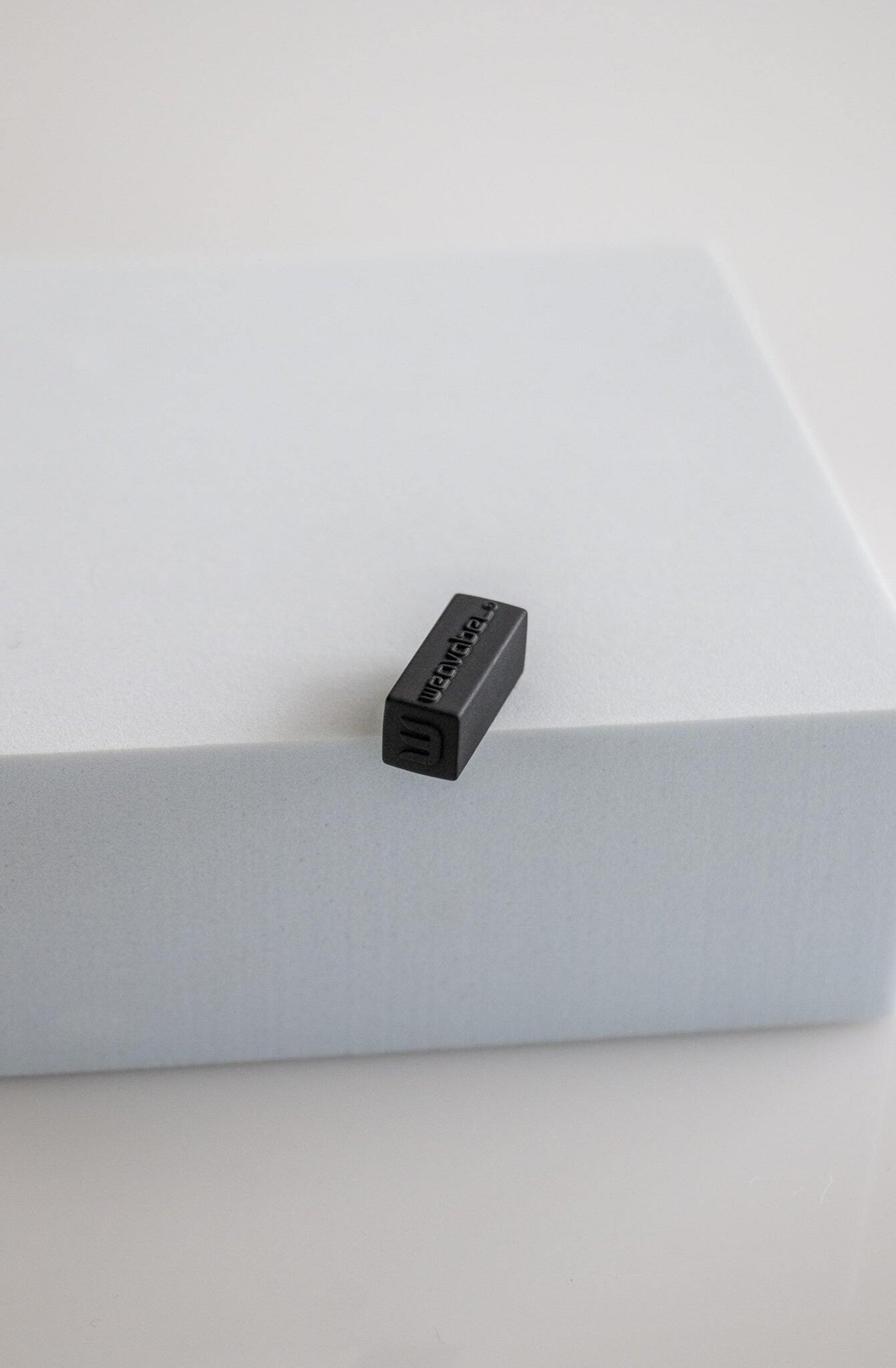 Weavabel moulded cord end with black rubberised coating.
