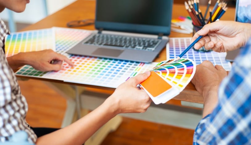 Two men choosing colour schemes from Pantone book