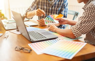 Two people picking colour tones on a kitchen table