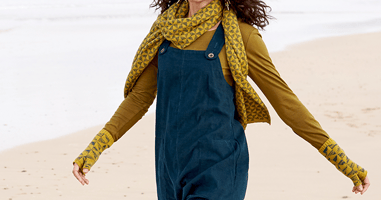Women dressed in dungarees walking across a beach