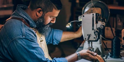 Worker sewing a belt on a machine