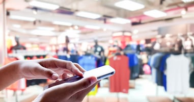 Customer using a phone in a store with blurred background