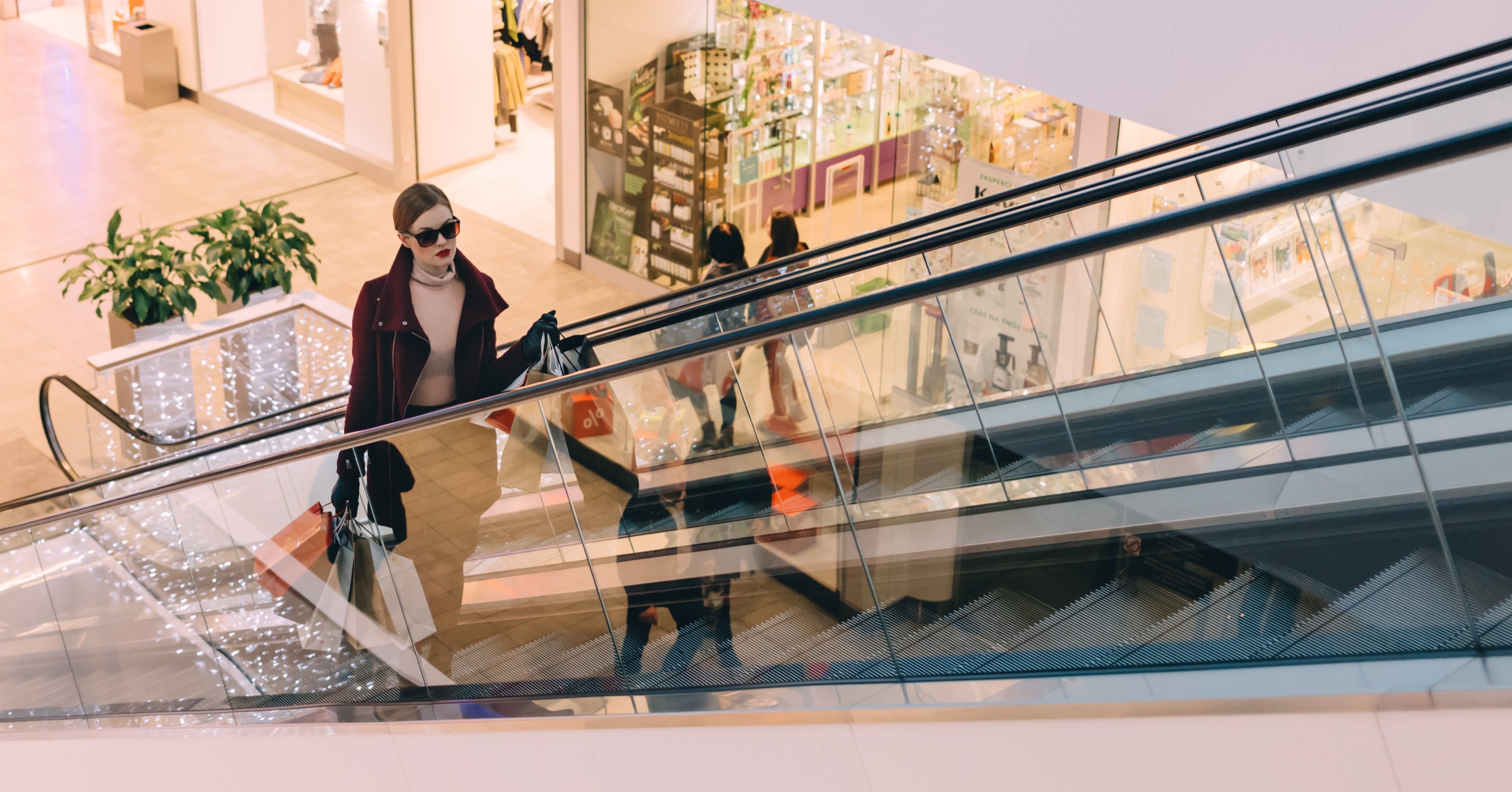 Model on an escalator with her shopping bags